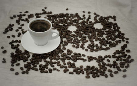 Cup and pot of coffee and coffee beans on beige background with smileの写真素材