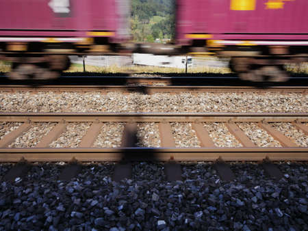Train in Rothrist, Switzerland is passing by with speed in front of a freeway or highwayの写真素材