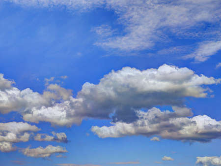 Blue cloudy sky with comic like deep plastic clouds. Shoot in Baden, Switzerlandの写真素材