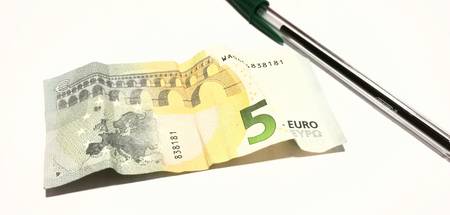 Money on the desk and a penの写真素材