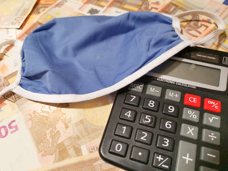 medical mask and calculator on euro paper moneyの写真素材