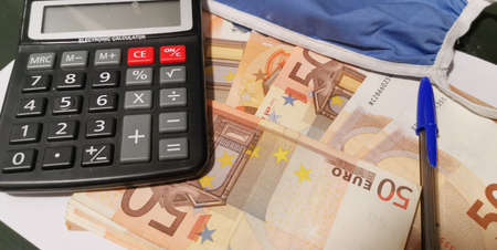 calculator medical mask and pen on paper moneyの写真素材