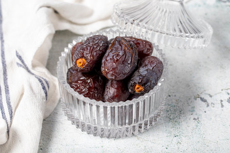 Jerusalem date fruit on stone background. Dried Big date fruit in a glass bowl. Ramadan food....