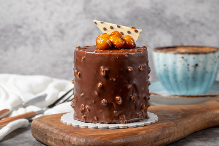 Chocolate and hazelnut cake on a dark background. With delicious dessert and coffee. Bakery...