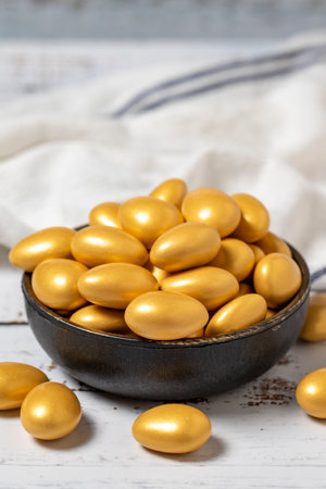 Golden chocolate dragee. Chocolate dragee on a white wood background. close upの写真素材