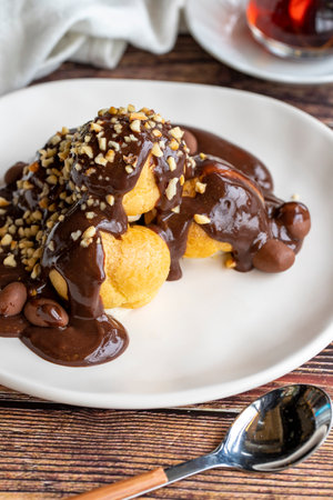 Profiterole dessert on wood background. Traditional french cuisine delicacies. Profiterole dessert...