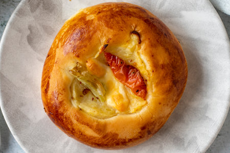 Turkish bagel pogaca with cheddar, tomato and pepper. traditional flavors. Pogaca on gray...