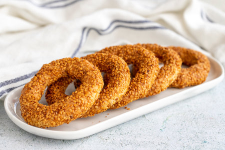 Sesame bagel on a gray background. Traditional Turkish cuisine delicacies. local name lamp ring