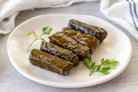 Stuffed leaves with olive oil on a stone background. Traditional Mediterranean cuisine delicacies. Local name olive oil leaf wrap or dolmadika. close upの写真素材