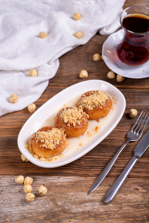 Milky kemalpasa dessert. Dessert with milk and hazelnuts on wooden background. Traditional Turkish...