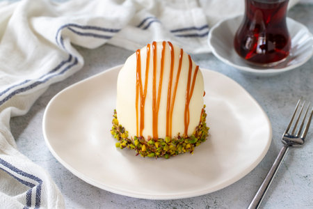 Pistachio and white chocolate cake on a gray background. Fruit and cream cake covered with chocolate...