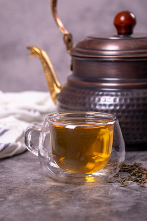 green tea. Green tea brewed with copper teapot on dark background. healthy drinks. Herbal tea concept. close upの写真素材
