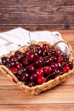 fresh cherries Ripe cherries in a basket on wood background. cherries close upの写真素材
