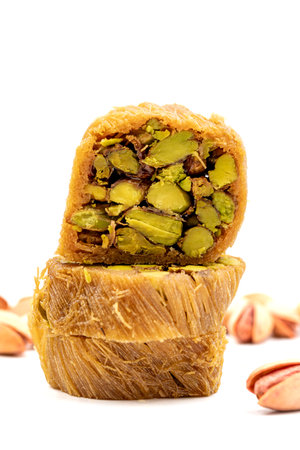 Pistachio kadayif. Kadayif baklava isolated on white background. Traditional Turkish cuisine delicacies. Kadayif dessert with syrup filled with pistachios in the middle. close upの写真素材