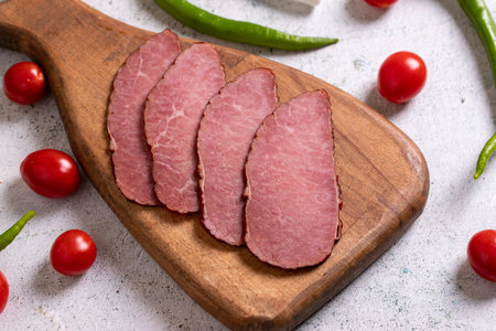 Beef jerky pieces. Sliced pieces of dry meat on a stone floor. close upの写真素材