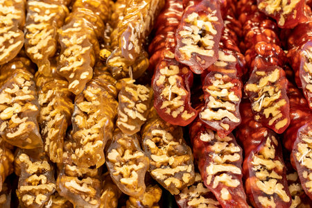 Walnut sausage with pomegranate walnuts and yellow grapes. sweet snack. close-up. local name walnut sausageの写真素材