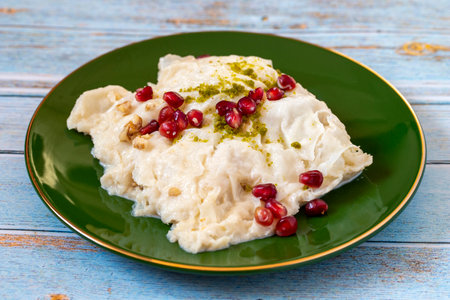 Gullac dessert on wooden background. Traditional Ramadan dessert. GÃ¼llaÃ§ dessert decorated with pistachio and pomegranate. Turkish cuisine delicacies. close upの写真素材