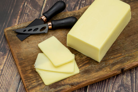 Kashar cheese or kashkaval cheese on wooden background. Sliced Cheddar Cheese