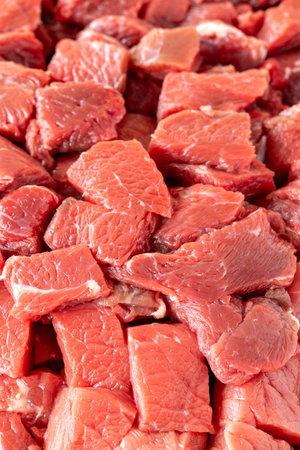 Meat cubes of beef on a white wooden background. Close-up meat. Meat backgroundの写真素材