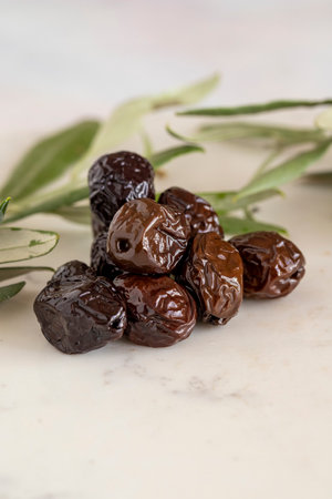 Close-up of black olives. Organic olives on a marble floorの写真素材