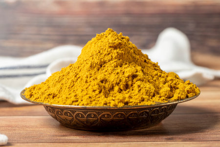 Curry Masala Powder. Turmeric powder or curry powder spice in a bowl on wooden background. Indian spices. Dry spice concept. close upの写真素材