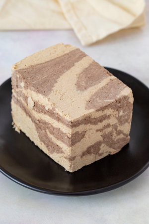 Halva with tahini and cocoa on wooden background. Local name halva with cocoa and tahini