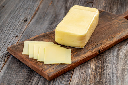 Kashar cheese or kashkaval cheese on wood floor. Cheese slices on the serving board