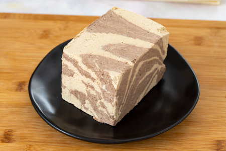 Halva with tahini and cocoa on wooden background. Local name halva with cocoa and tahini
