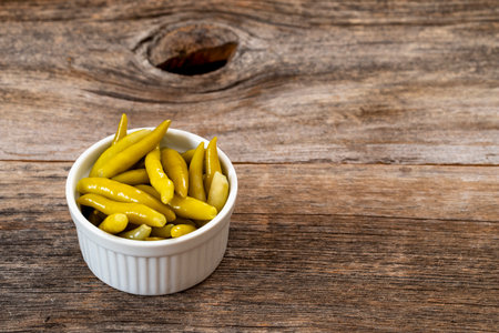 Green chilli pepper pickled on wooden background. copy spaceの写真素材