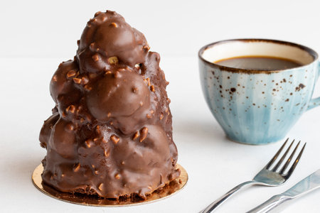 Profiterole tower cake on a white background. Along with a cup of coffeeの写真素材