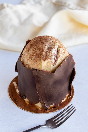 Cake with banana and profiteroles on a white background. Small celebration dessert covered with...