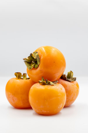 Fresh organic ripe persimmons fruits on a white background with shadow. Close up persimmons fruitsの写真素材