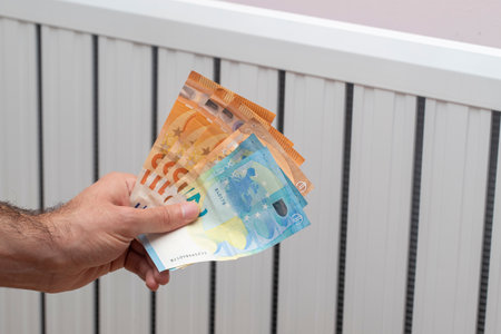 European energy crisis. increase in gas prices in Europe for the population. Euro banknotes in front of a burning radiatorの写真素材