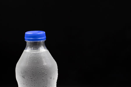 Pet bottle filled with water on a black background. close-up. Horizontal view