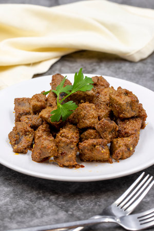 Fried liver cubes on a dark background. Turkish Traditional Food Albanian Cigar. vertical view. close upの写真素材