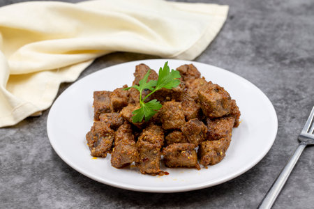 Fried liver cubes on a dark background. Turkish Traditional Food Albanian Cigar. Horizontal view....