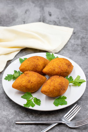Kibbeh on a dark background. Kibbeh is a popular dish in Middle Eastern cuisine. Stuffed Meatballs Food, Falafel, icli Kofta, Quibe. vertical view. close upの写真素材