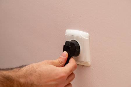 The hand of the person inserting the plug
