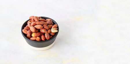 peanuts in bowl on white wooden backgroundの写真素材