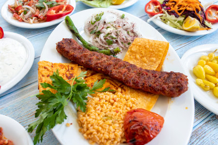 in the plate with the hot kebab and appetizers. Adana kebabの写真素材