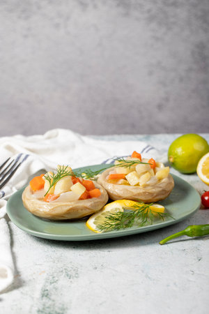 Artichoke with vegetables on gray floor. Artichoke dinner made with olive oil, potatoes, carrots and onions. healthy foodの写真素材