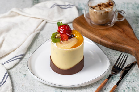 Chocolate and fruitcake. Bakery products. Chocolate covered cake on gray background. Cake made with strawberry, kiwi, raspberry, pear and peachの写真素材