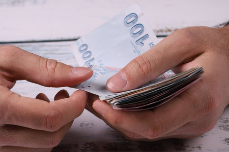 Young man counting Turkish banknotes in his hand. Turkish Lira TRY or TLの写真素材
