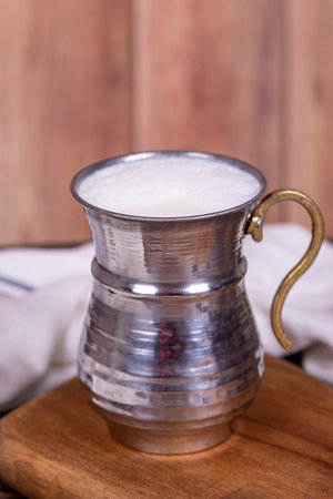 buttermilk. Sparkling buttermilk in an iron glass. Beverage prepared with yogurt and water....