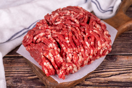 Minced meat on wood background. Raw minced cow meat or ground meat. close upの写真素材