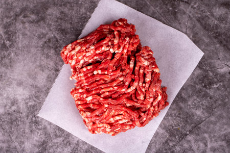 Minced meat on butcher paper. Fresh ground beef on wood background. Top viewの写真素材