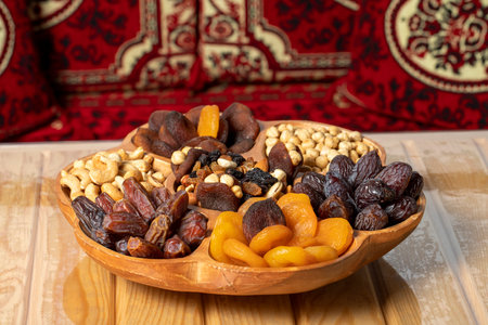 Mixed nut platter. Wood nut plate prepared with hazelnuts, cashews, dates, apricots and grapes.の写真素材