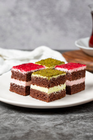 Small cake slices. Pistachio and raspberry cake slices. Set of different tartlets or cakes. Bakery products. close upの写真素材