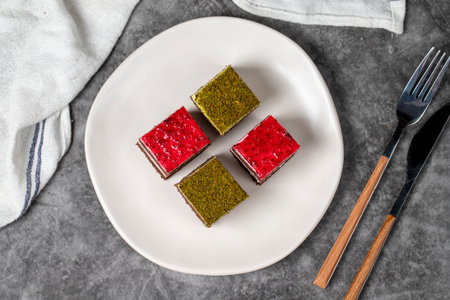 Small cake slices. Pistachio and raspberry cake slices. Set of different tartlets or cakes. Bakery...