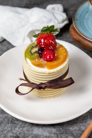 Fruitcake. Strawberry, pear, kiwi and raspberry cake covered with white chocolate on a dark...